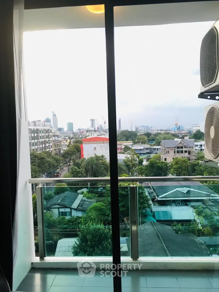 Stunning cityscape view from a modern balcony with lush greenery and urban skyline.