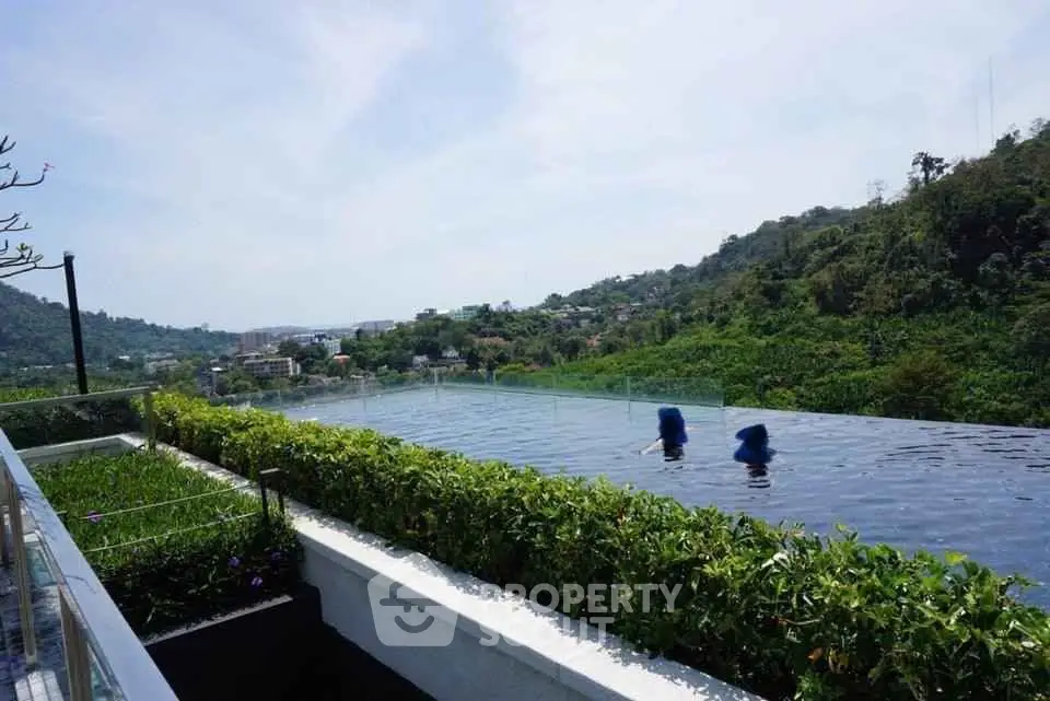 Luxurious infinity pool with stunning hillside views and lush greenery.