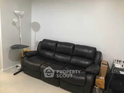 Cozy living room with black leather sofa and modern floor lamp