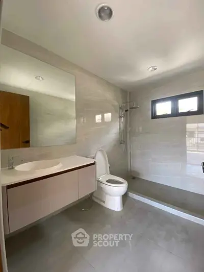 Modern bathroom with sleek design, featuring a spacious shower and elegant vanity.
