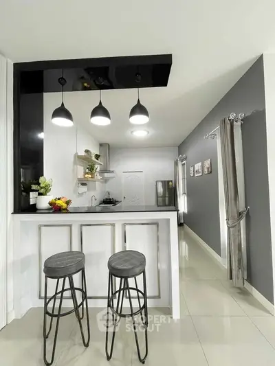 Modern kitchen with sleek design, featuring an open layout and stylish bar stools.
