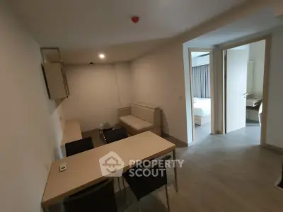 Modern apartment interior with open living and dining area, featuring neutral tones and sleek furniture.