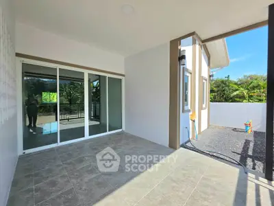 Spacious modern patio with sliding glass doors and tiled flooring