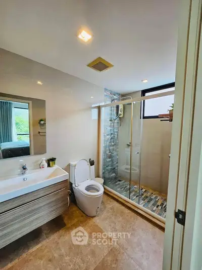 Modern bathroom with glass shower and stylish vanity in a bright, contemporary home.