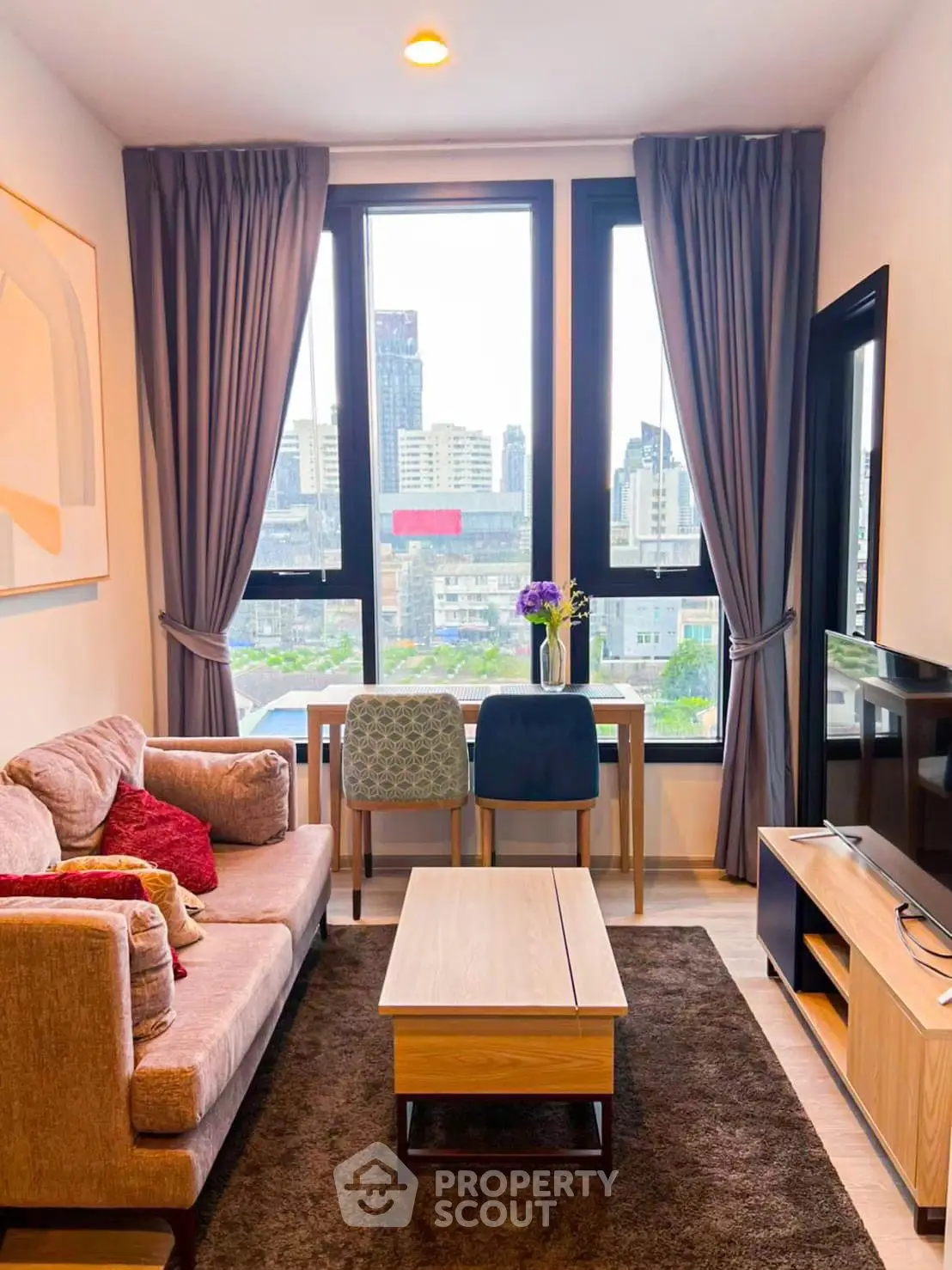 Modern living room with city view, stylish furniture, and natural light.