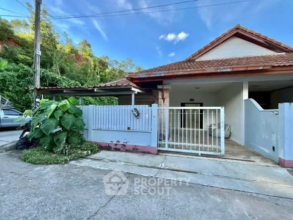 Charming suburban house with gated entrance and tiled roof, perfect for family living.
