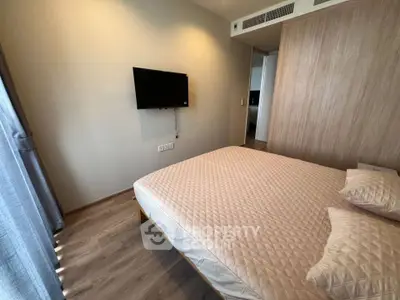 Modern bedroom with wall-mounted TV and stylish wood paneling