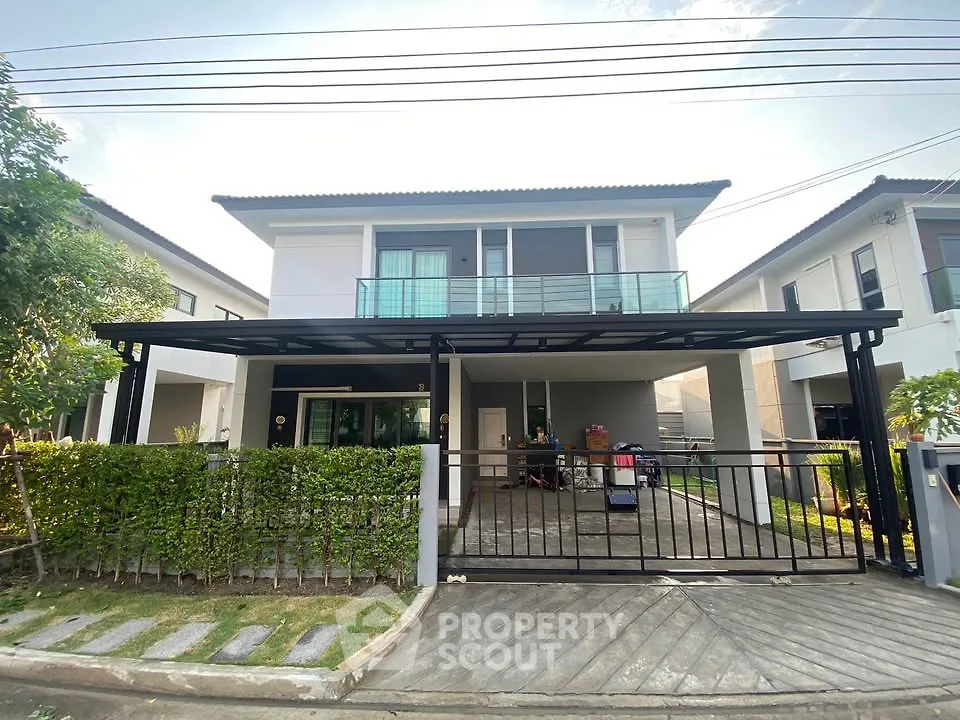 Modern two-story house with spacious driveway and lush greenery