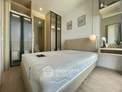 Modern bedroom with stylish decor and ample natural light, featuring a comfortable bed and sleek storage solutions.