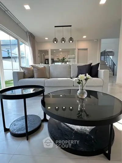 Modern living room with stylish furniture and large windows offering natural light