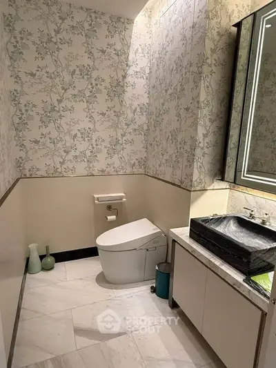Elegant bathroom with modern fixtures and floral wallpaper, featuring a sleek toilet and stylish sink.
