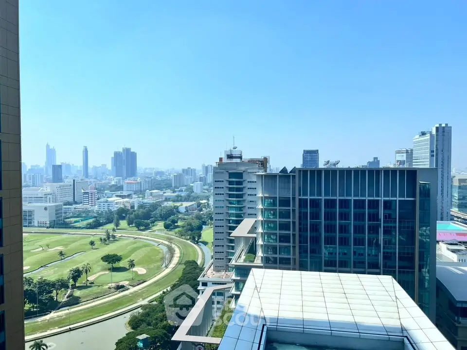 Stunning cityscape view from high-rise building overlooking golf course and skyline.