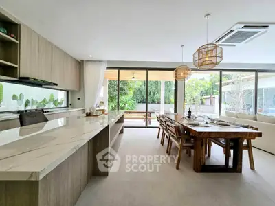 Luxurious open-plan kitchen and dining area with modern decor and garden view.