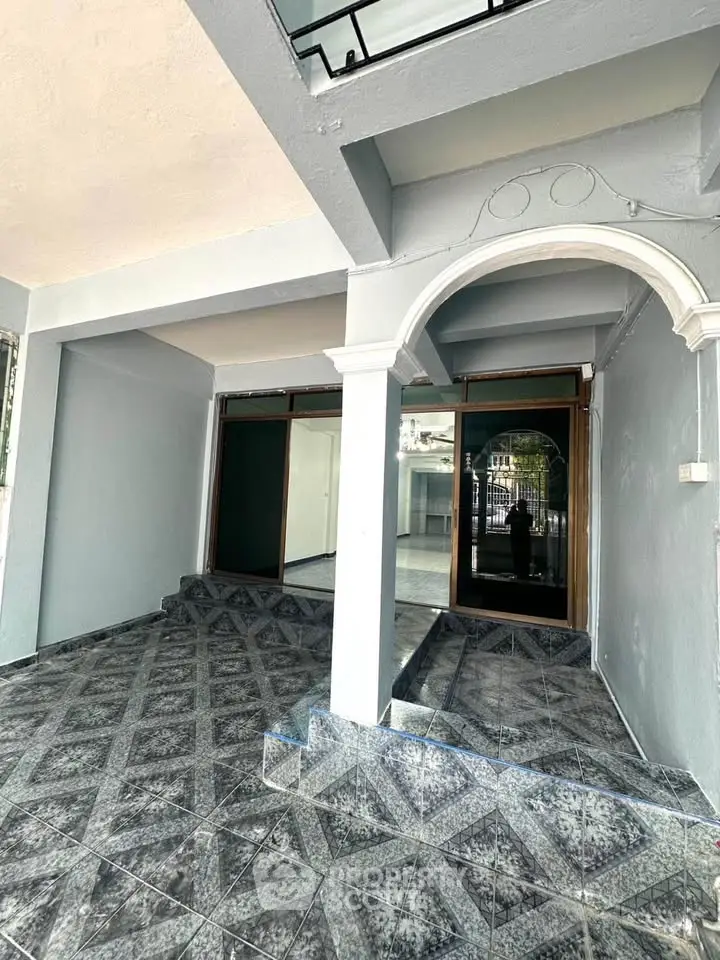 Spacious entrance with elegant tiled flooring and archway in modern building