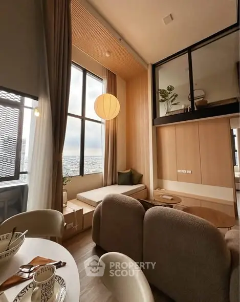 Modern living room with large windows and cozy seating area, offering a stunning city view.