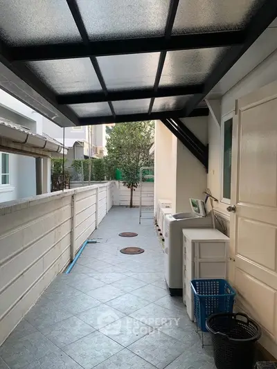Charming outdoor laundry area with modern appliances and covered walkway in a residential property.