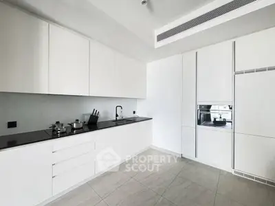Modern kitchen with sleek white cabinetry and built-in appliances