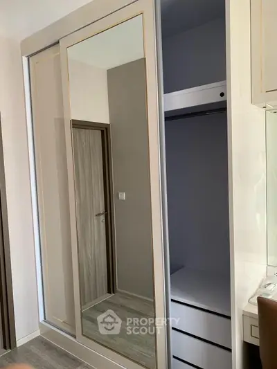 Modern bedroom with sleek mirrored wardrobe and stylish interior design.