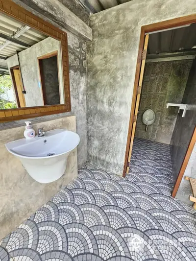 Rustic bathroom with unique tile flooring and concrete walls