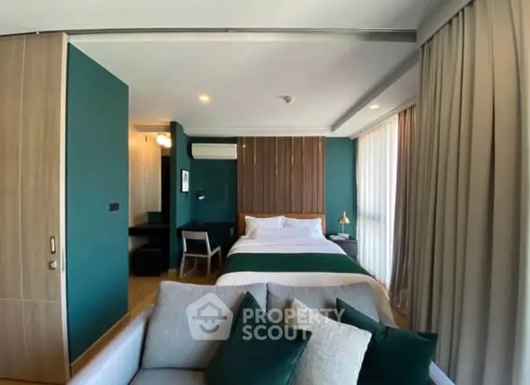 Modern bedroom with stylish decor and cozy seating area in a contemporary apartment.
