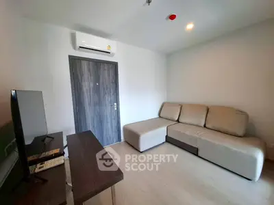 Modern living room with cozy sofa and flat-screen TV, perfect for relaxation.