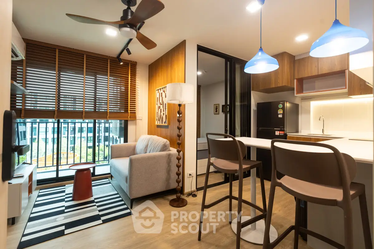 Modern living room with open kitchen, stylish decor, and large windows in a contemporary apartment.