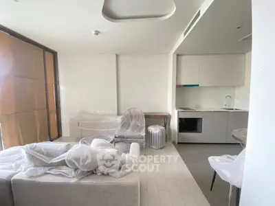 Modern living room with open kitchen layout and stylish furniture in a bright apartment.