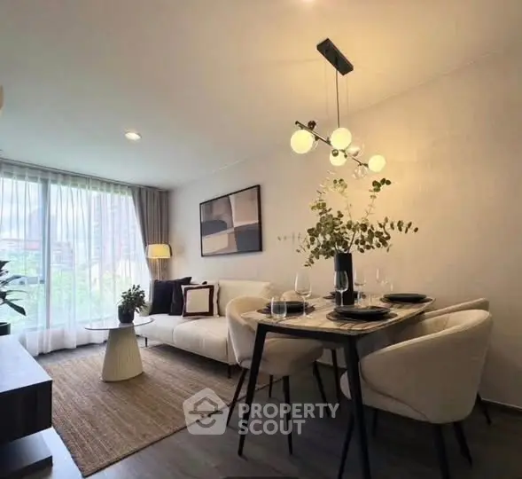 Modern living room with dining area, stylish decor, and large window view.
