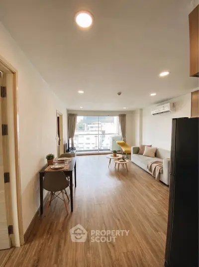 Spacious modern living room with wooden flooring and natural light