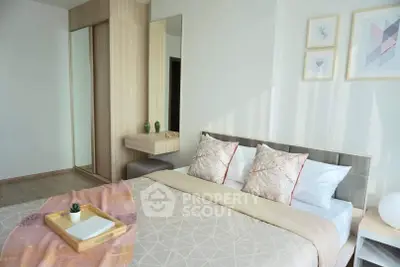 Modern bedroom with stylish decor and natural light, featuring a cozy bed and elegant artwork.