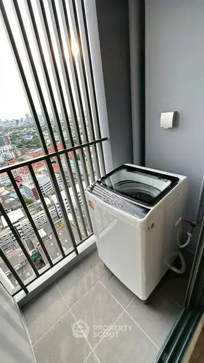High-rise balcony with washing machine and city view, perfect for urban living.