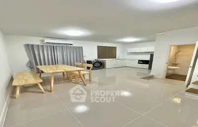 Spacious open-plan living area with gleaming tiled floors, modern kitchen appliances, and ample natural light, perfect for entertaining and comfortable living.