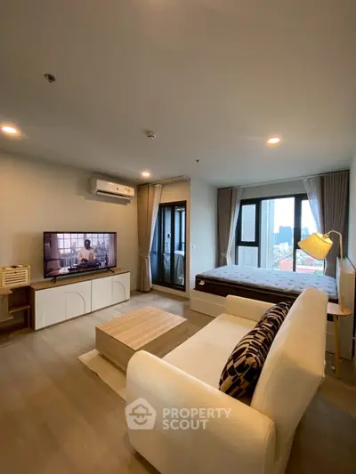 Modern studio apartment with cozy living area and city view