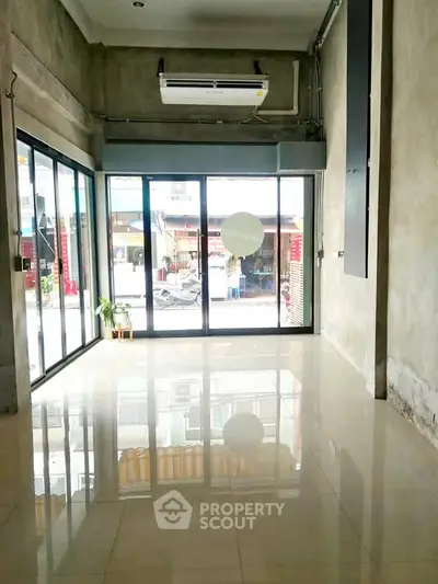 Spacious empty room with large windows and polished floors, ideal for customization.