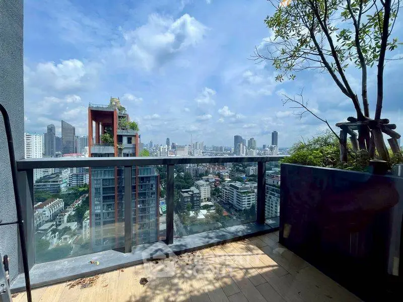 Stunning cityscape view from a modern balcony with lush greenery and clear skies.