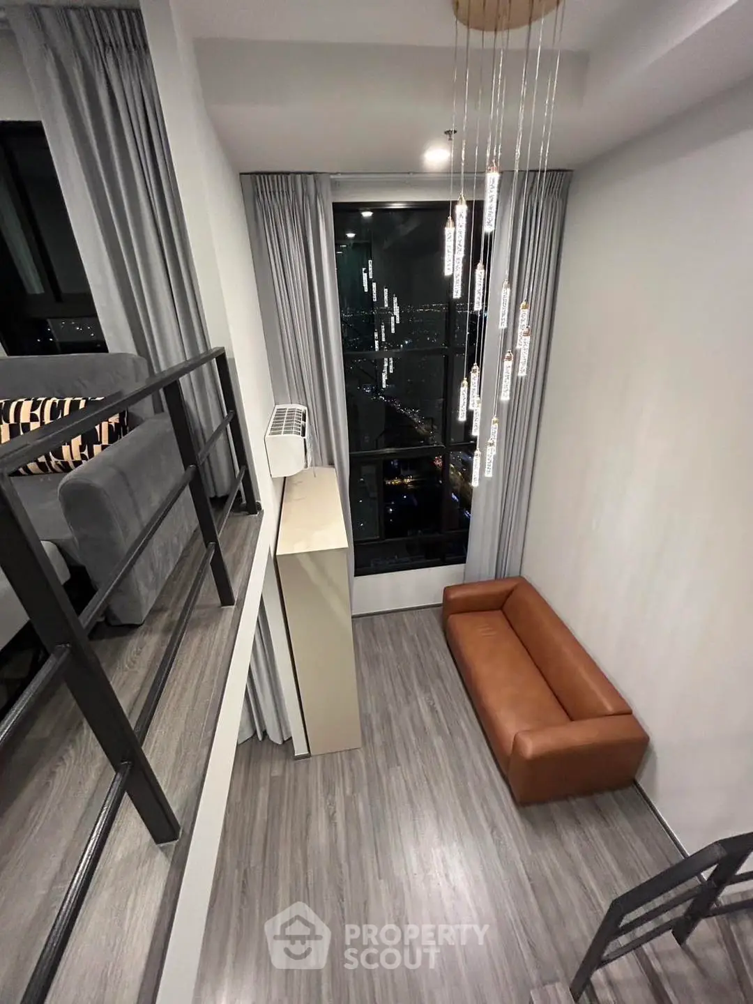 Modern loft-style living room with high ceiling and large window view.