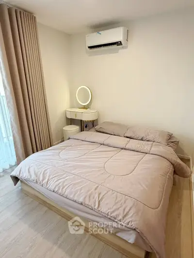 Cozy bedroom with modern decor and natural light, featuring a comfortable bed and stylish vanity.