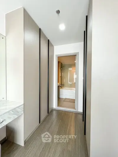 Modern hallway leading to a stylish bathroom with sleek design