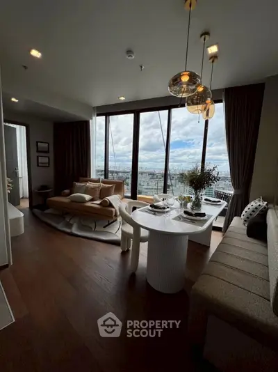 Luxurious living room with stunning city view, elegant decor, and modern furniture in a high-rise apartment.