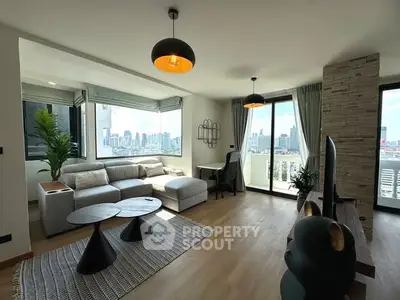 Modern living room with city view, stylish furniture, and natural light.