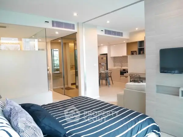 Modern open-plan bedroom with stylish decor and view into living area
