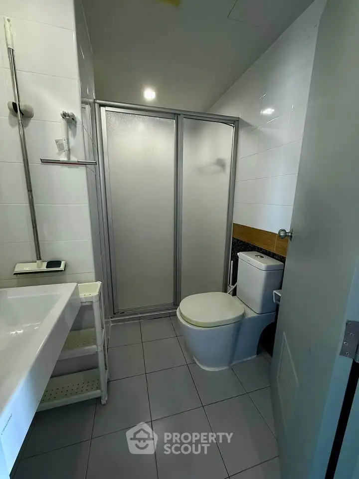 Modern bathroom with sleek shower and contemporary fixtures in a stylish apartment.