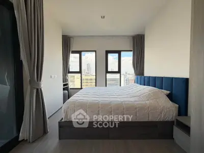 Spacious bedroom with city view and modern decor in a high-rise apartment.