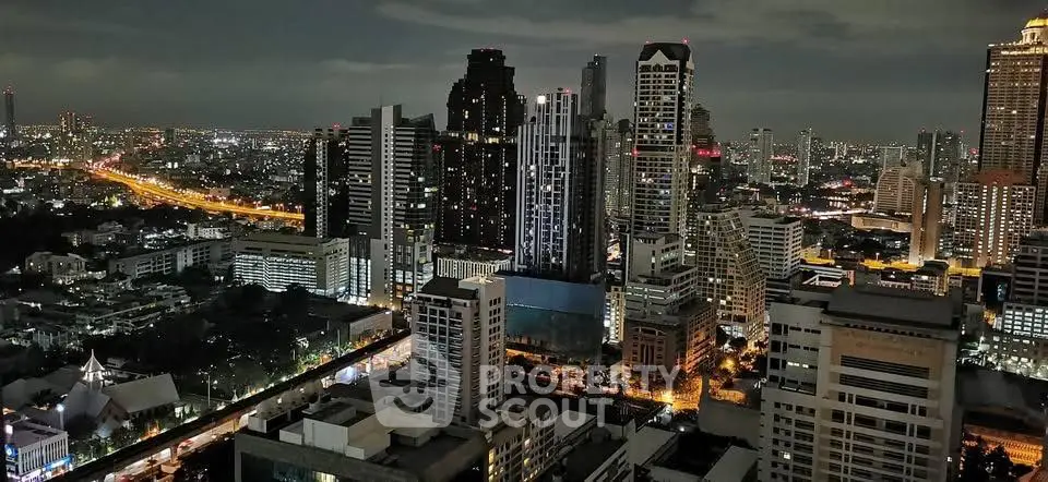 Stunning cityscape view of illuminated skyscrapers at night showcasing urban living.