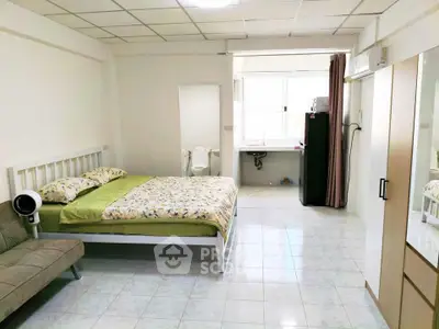 Spacious bedroom with modern furnishings and natural light in a cozy apartment.