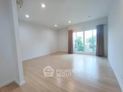 Spacious empty living room with large windows and wooden flooring