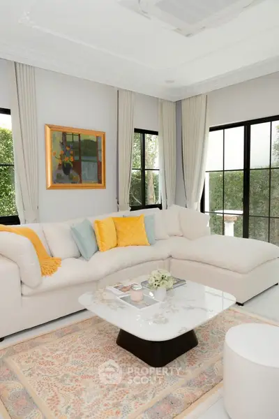 Luxurious living room with elegant decor and large windows offering serene garden views.