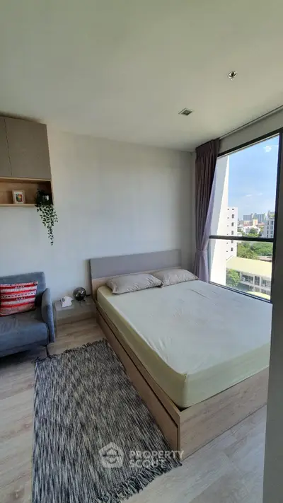 Modern bedroom with large window and cozy decor in urban apartment