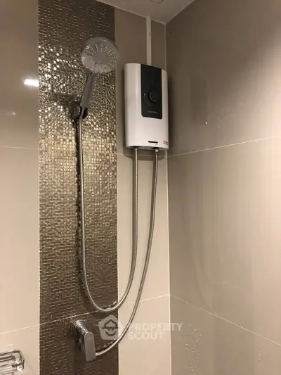 Modern bathroom with sleek shower and water heater, featuring elegant tile design.