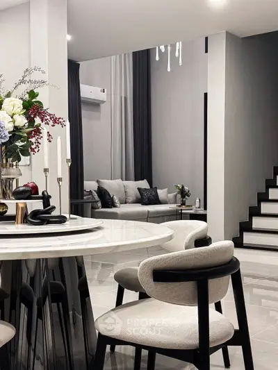 Modern living room with elegant dining area and stylish staircase